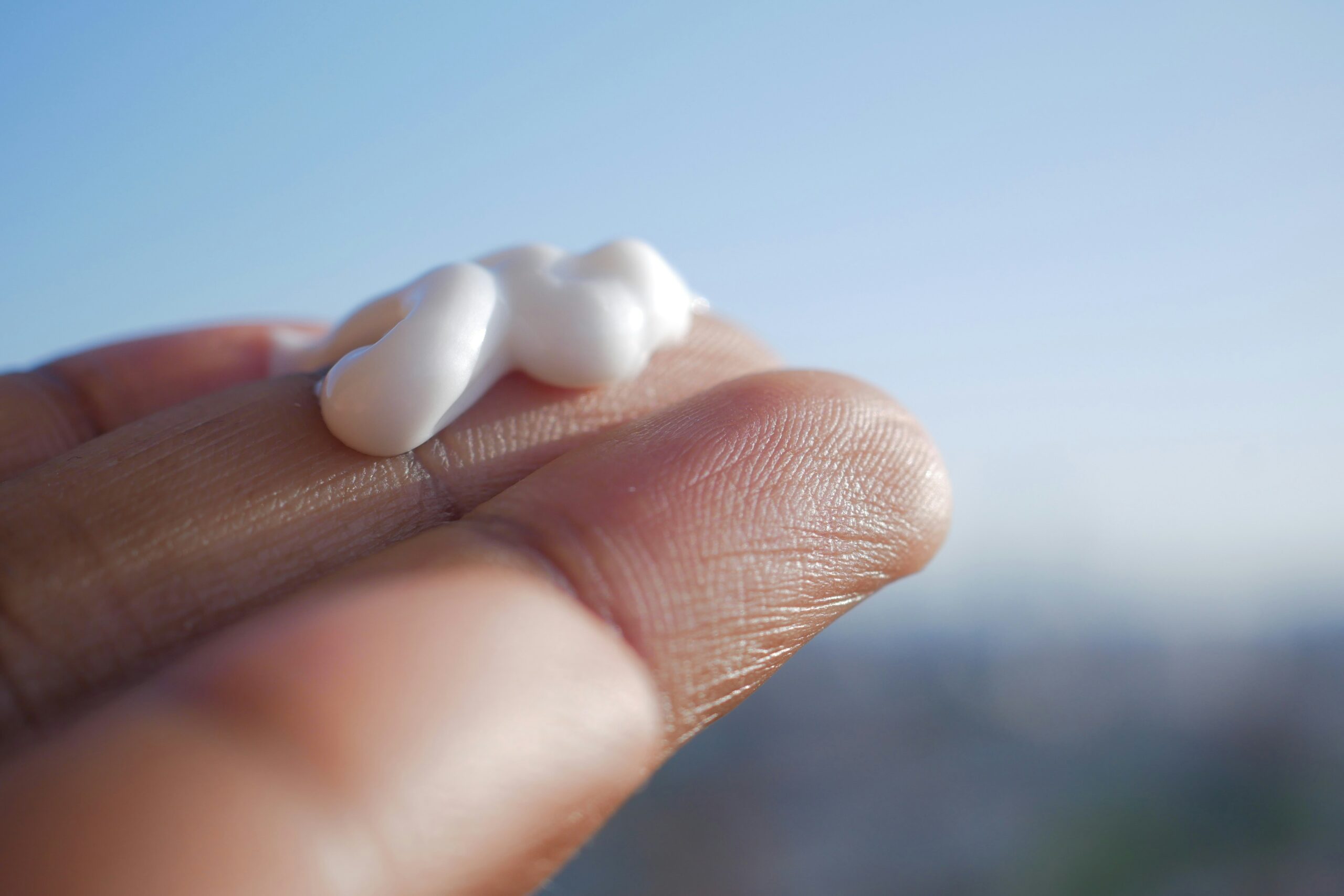 A hand holding a small piece of marshmallow